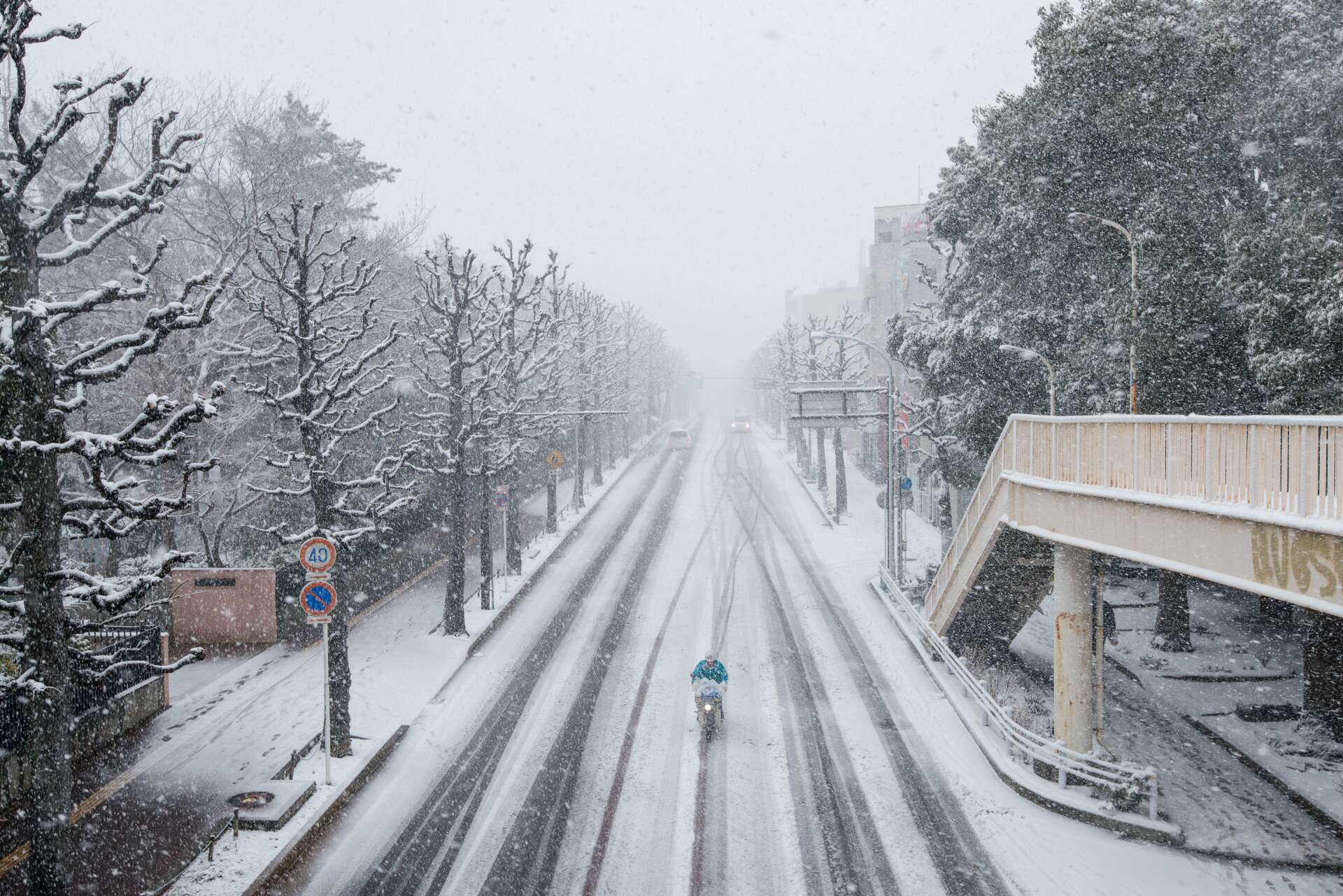 Radfahren im Winter ist meist mit viel Platz verbunden - doch bei Schnee im Zweifelsfall lieber schieben. Leicht schneebeckte Fahrbahn auf der ein einsamer Radfahrer unterwegs ist.