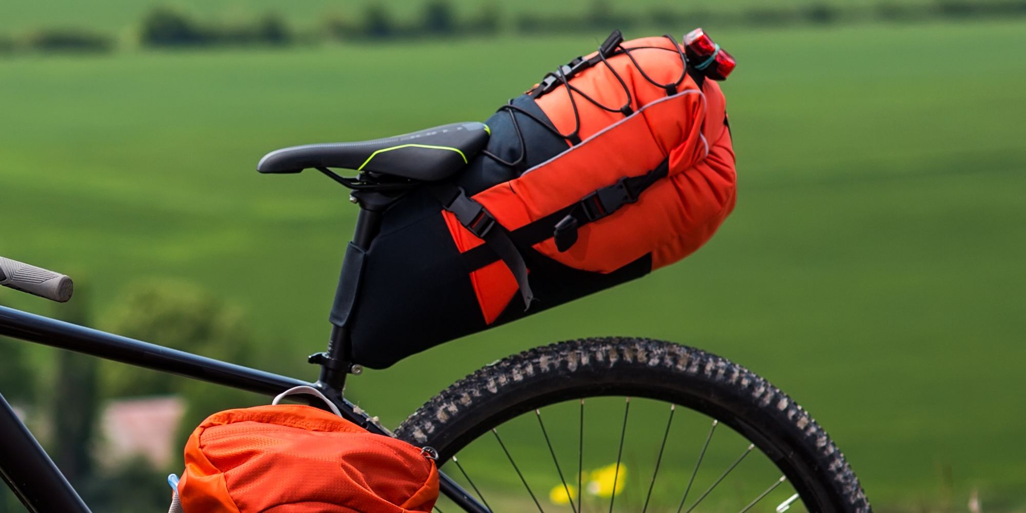 Farbige Satteltasche am Fahrrad vor einer grünen Wiese