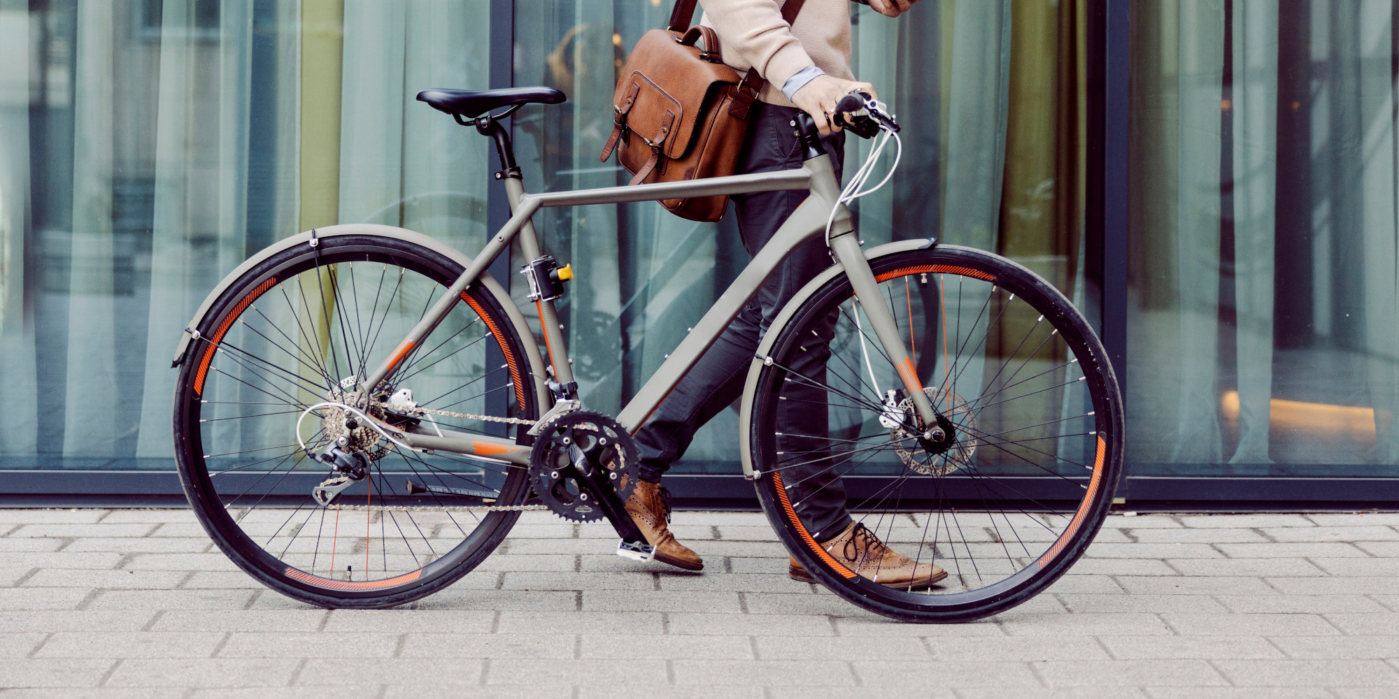 Mann schiebt ein Citybike durch die Stadt