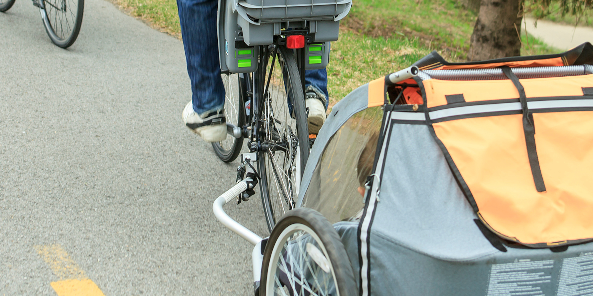 Ein Fahrrad mit einem Anhänger auf einem Radweg.