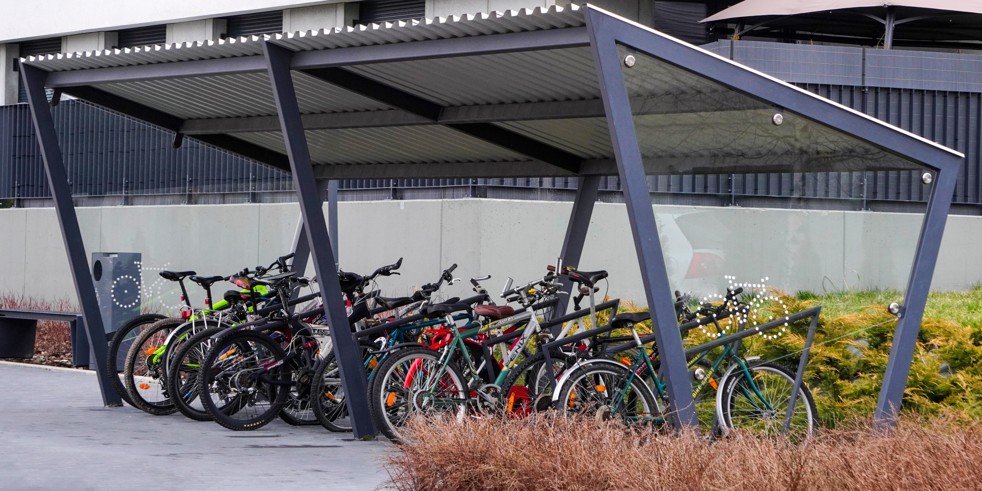 Fahrrad Abstellplatz mit mehreren Fahrrädern unter einem modernen Dach.