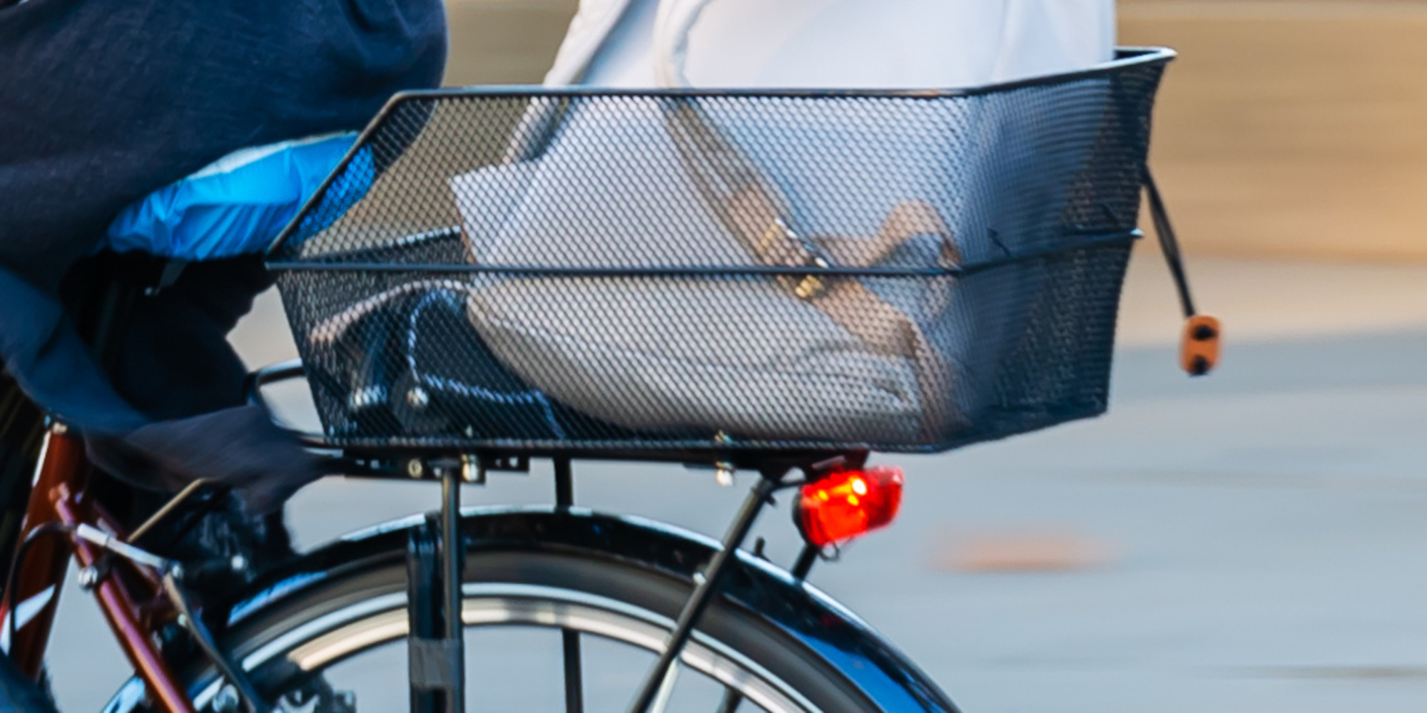 Ein Fahrrad mit einem Korb auf dem Gepäckträger, gefüllt mit weißem Stoff.