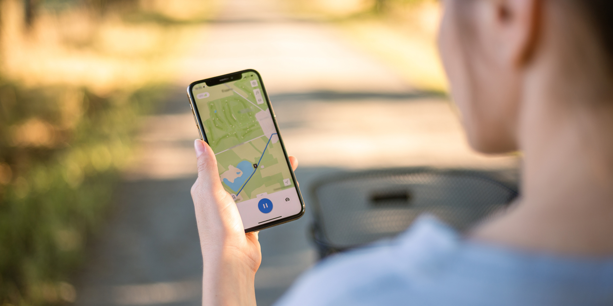 Frau guckt auf ihr Handy auf dem ein Standort angezeigt wird