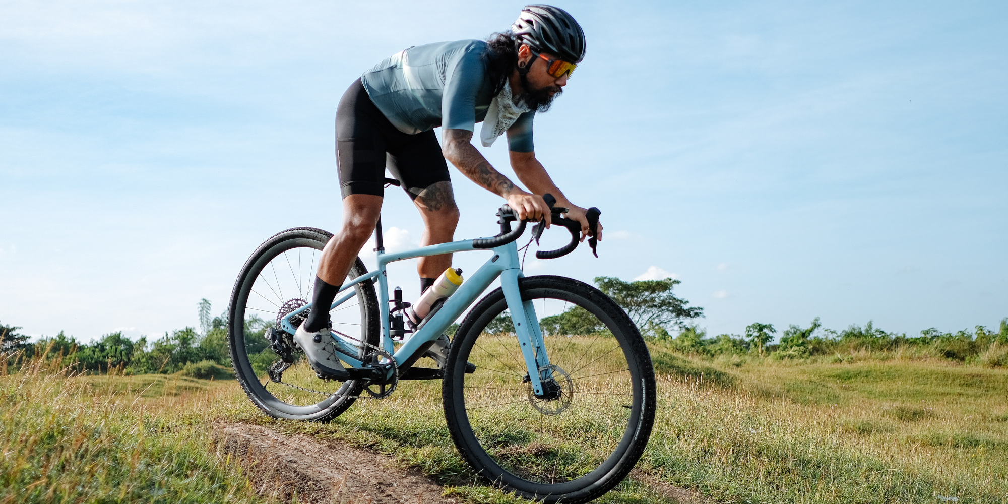 Radfahrer fährt mit einem Gravelbike über eine Wiese