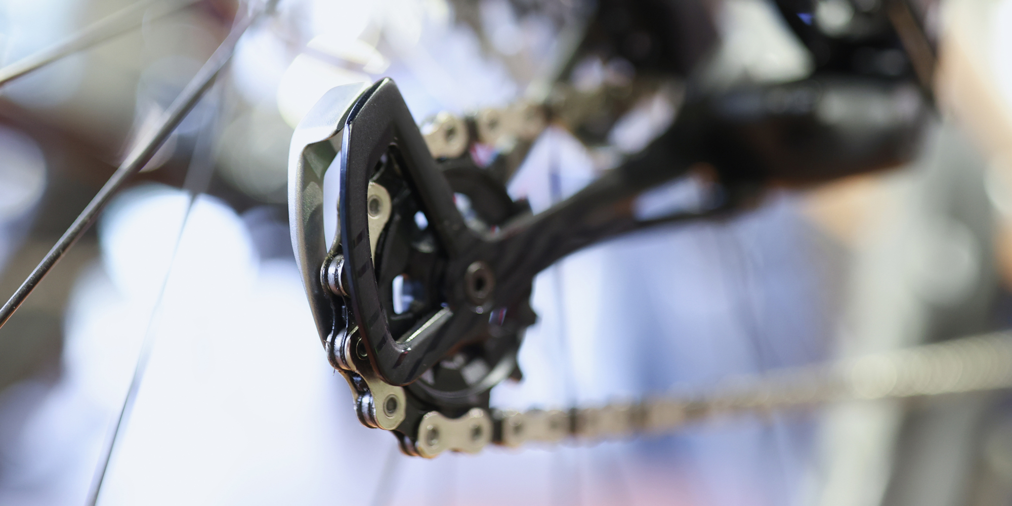 Nahaufnahme einer Shimano Fahrradschaltmechanik mit Kette auf unscharfem Hintergrund.