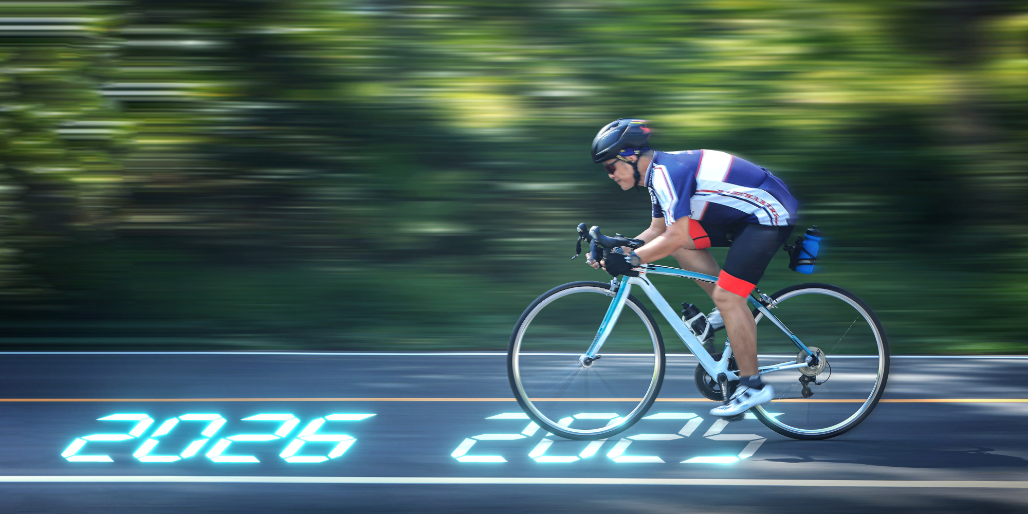 Rennradfahrer auf einer Straße, Geschwindigkeit suggeriert durch verschwommene Bewegung.