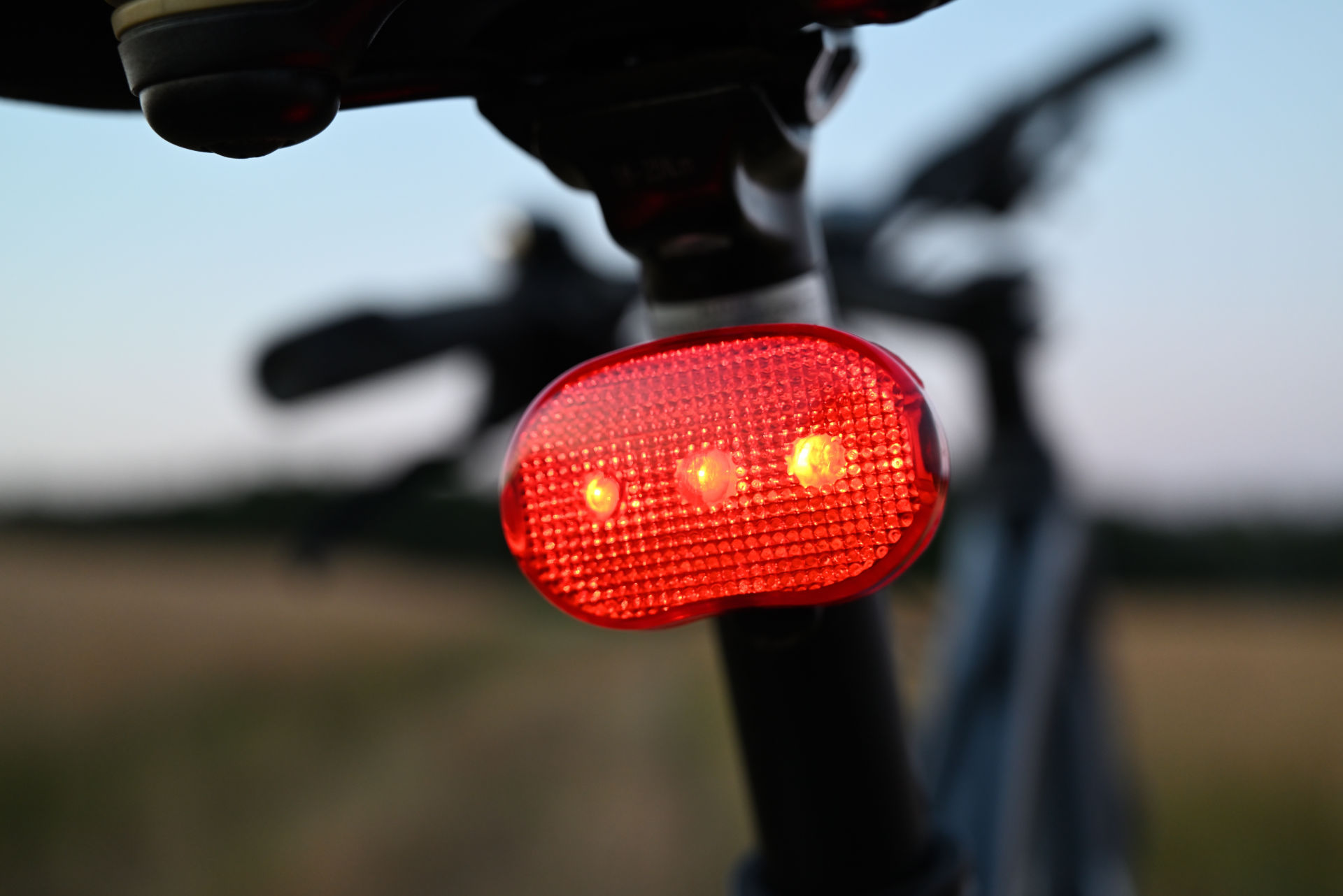 Ein Fahrrad mit eingeschaltetem Rücklicht steht auf einer Wiese