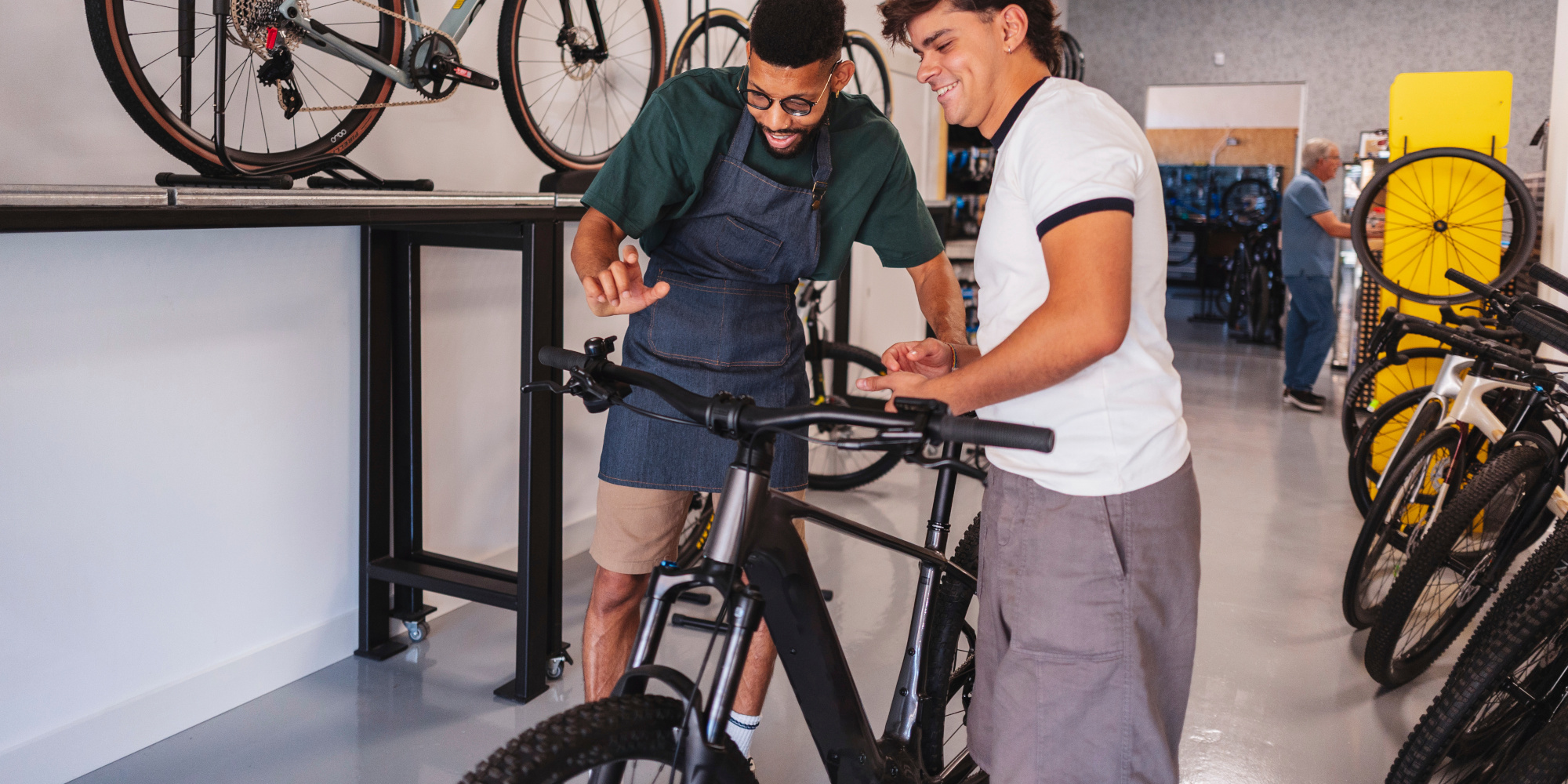 Zwei Männer in einem Fahrradgeschäft betrachten ein Fahrrad und diskutieren darüber.