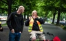 Zwei Männer unterhalten sich auf einem Weg, einer sitzt auf einem Fahrrad und zeigt Daumen hoch.
