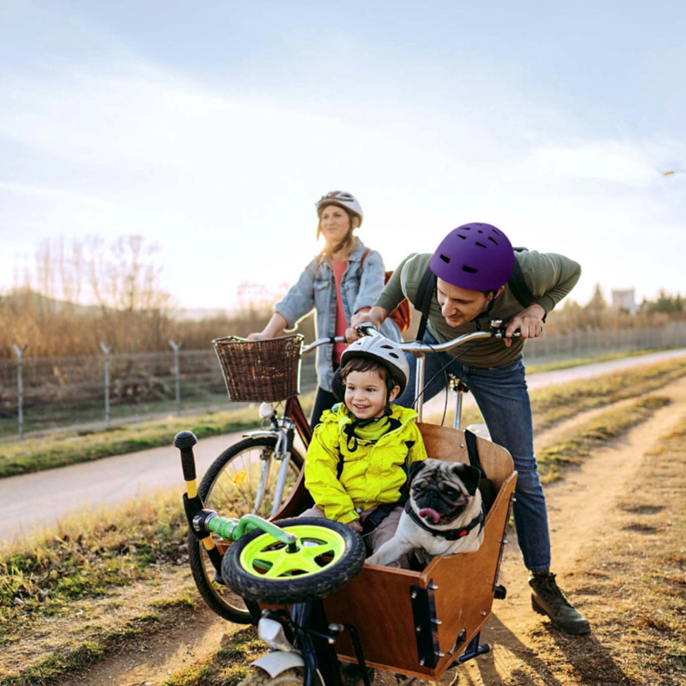 Fröhliche Familienradtour mit Fahrrad und Lastenrad mit Kind und Hund im Anhänger 