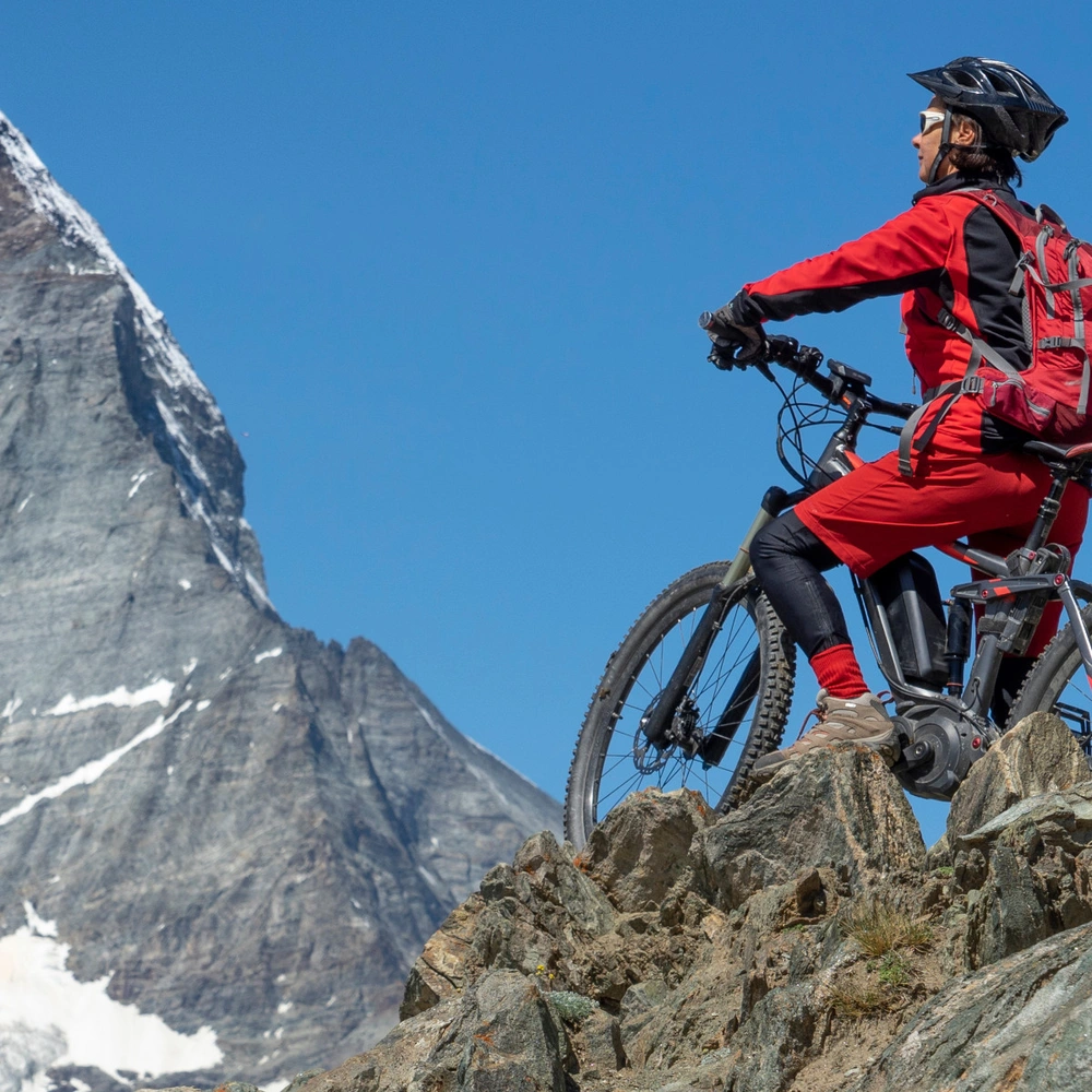 Frau fährt mit einem E-Mountainbike in den Schweizer Alpen