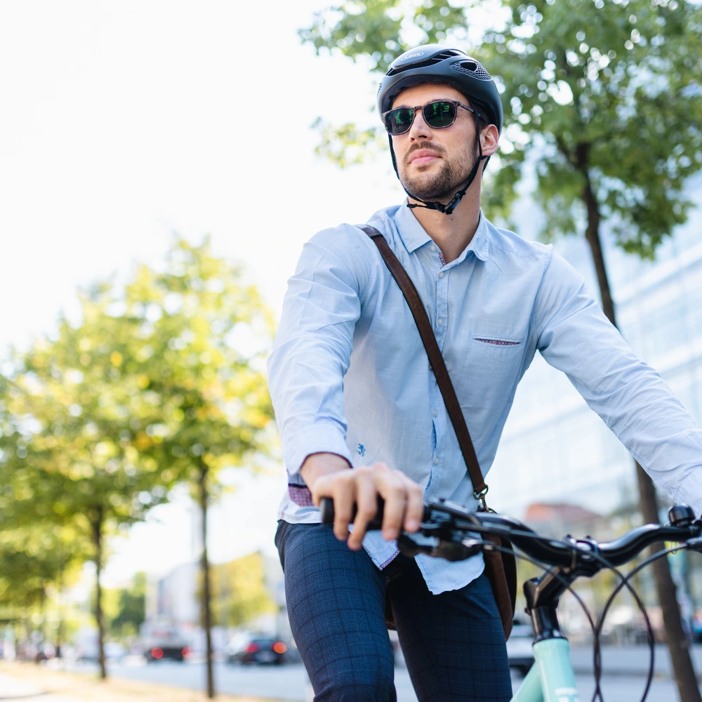 Mann mit Helm fährt mit seinem Bike durch die Stadt