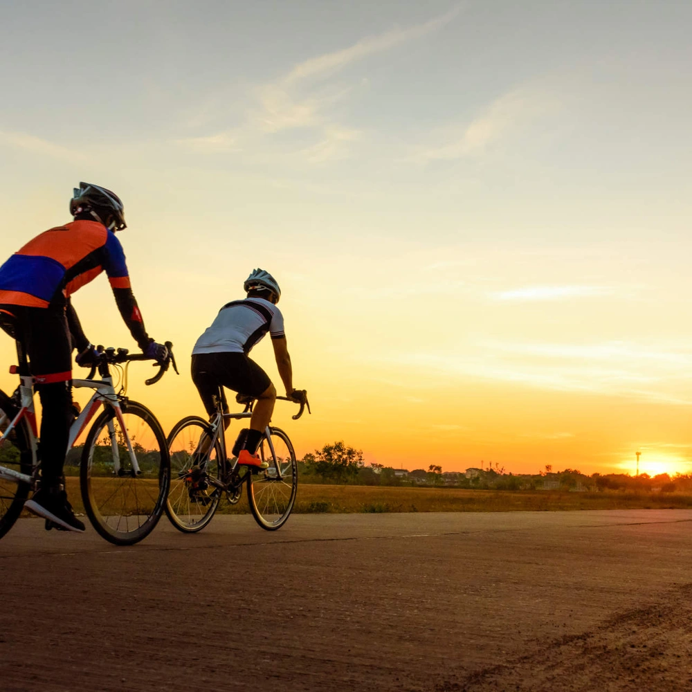 Zwei Fahrradfahrer machen eine Radtour in der Dämmerug
