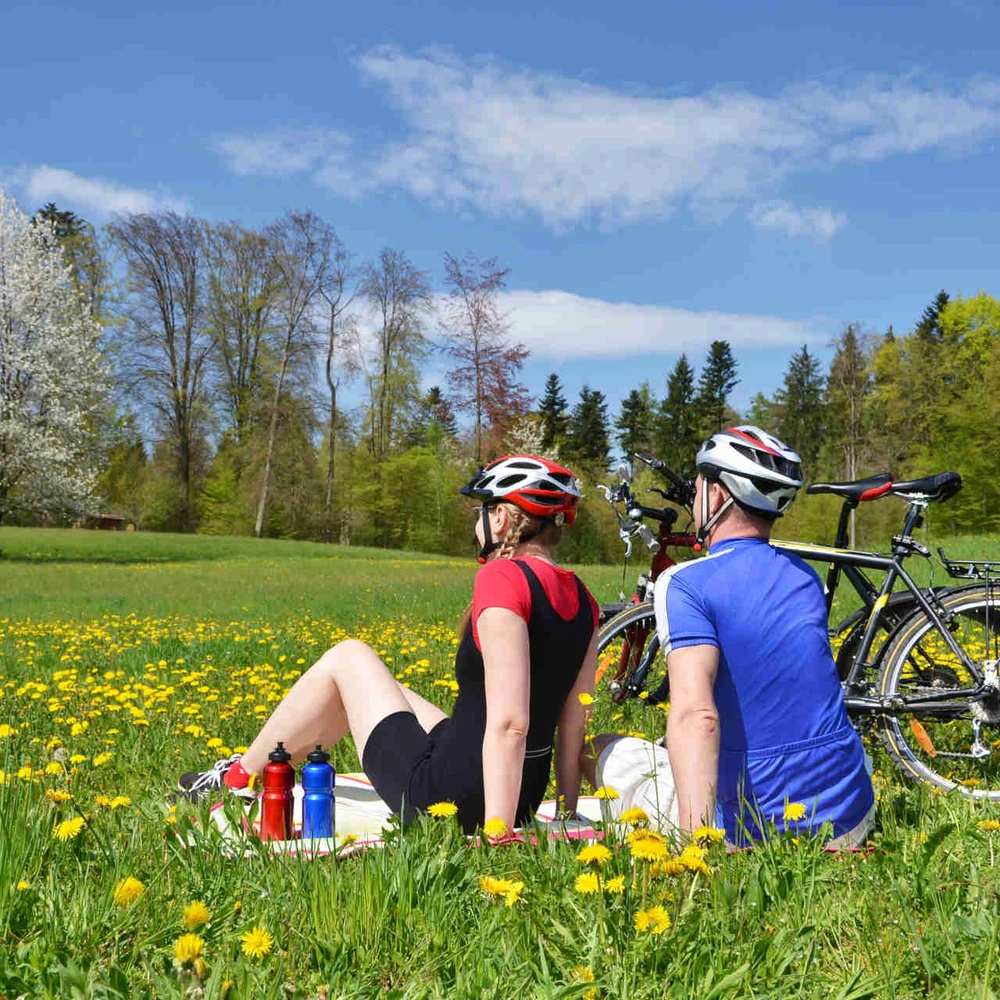 Zwei Personen sitzen neben ihren Rädern in der Sonne