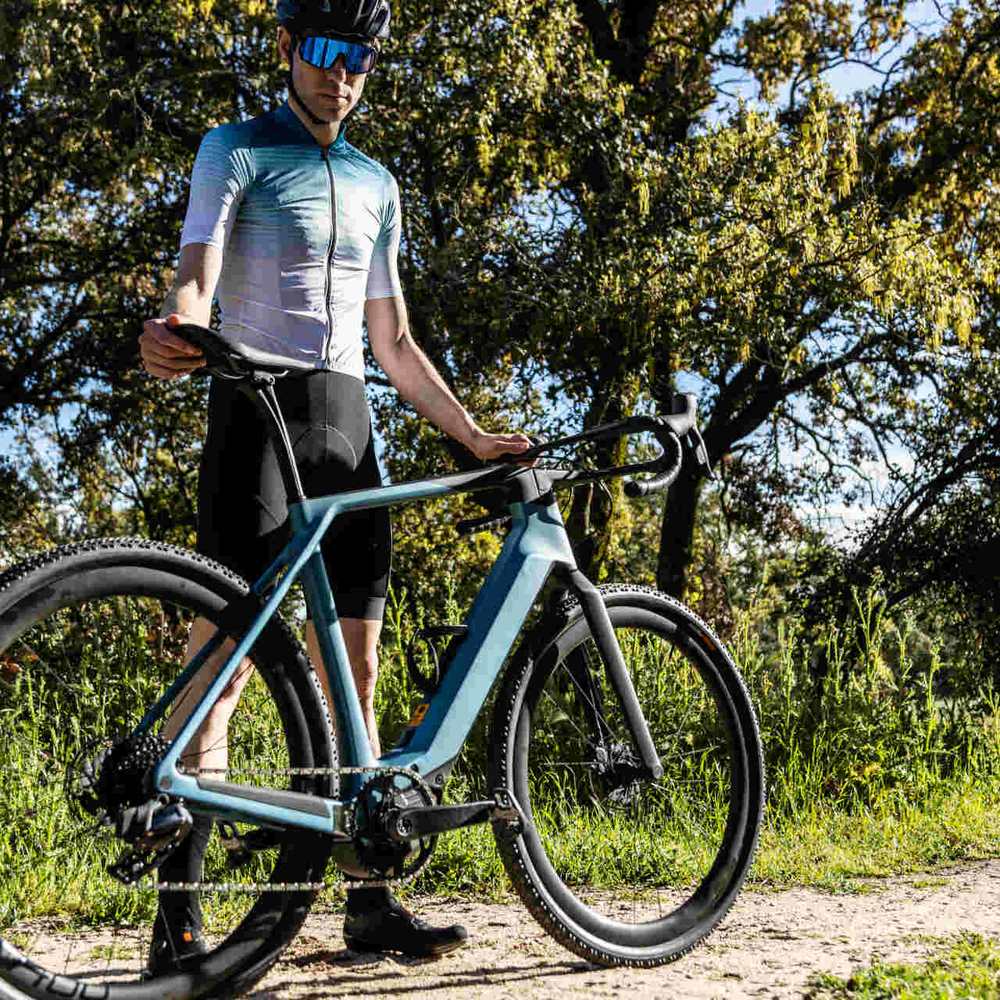Advanced E-Bikes aus Kunststoffgranulat – das musst du wissen. Mann steht neben futuristischem E-Bike