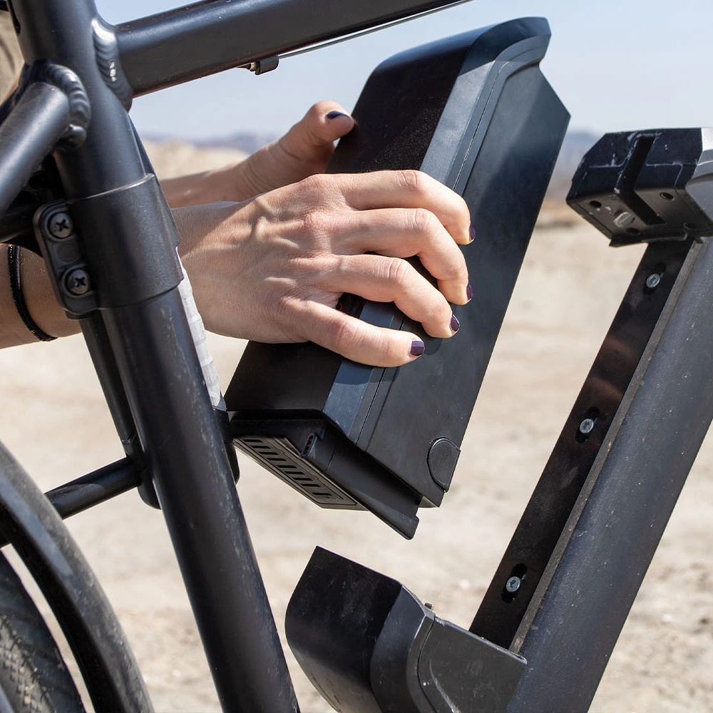 E-Bike Akku wird von einer Hand aus Fahrrad gelöst