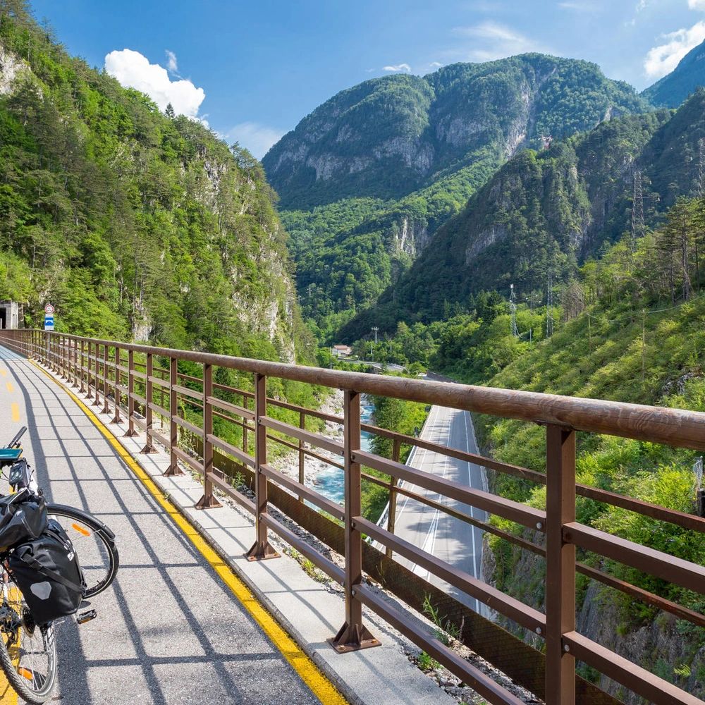 Alle Infos zum Alpe-Adria-Radweg Fahrrad steht auf einer Brücke auf dem Alpe-Adria-Radweg