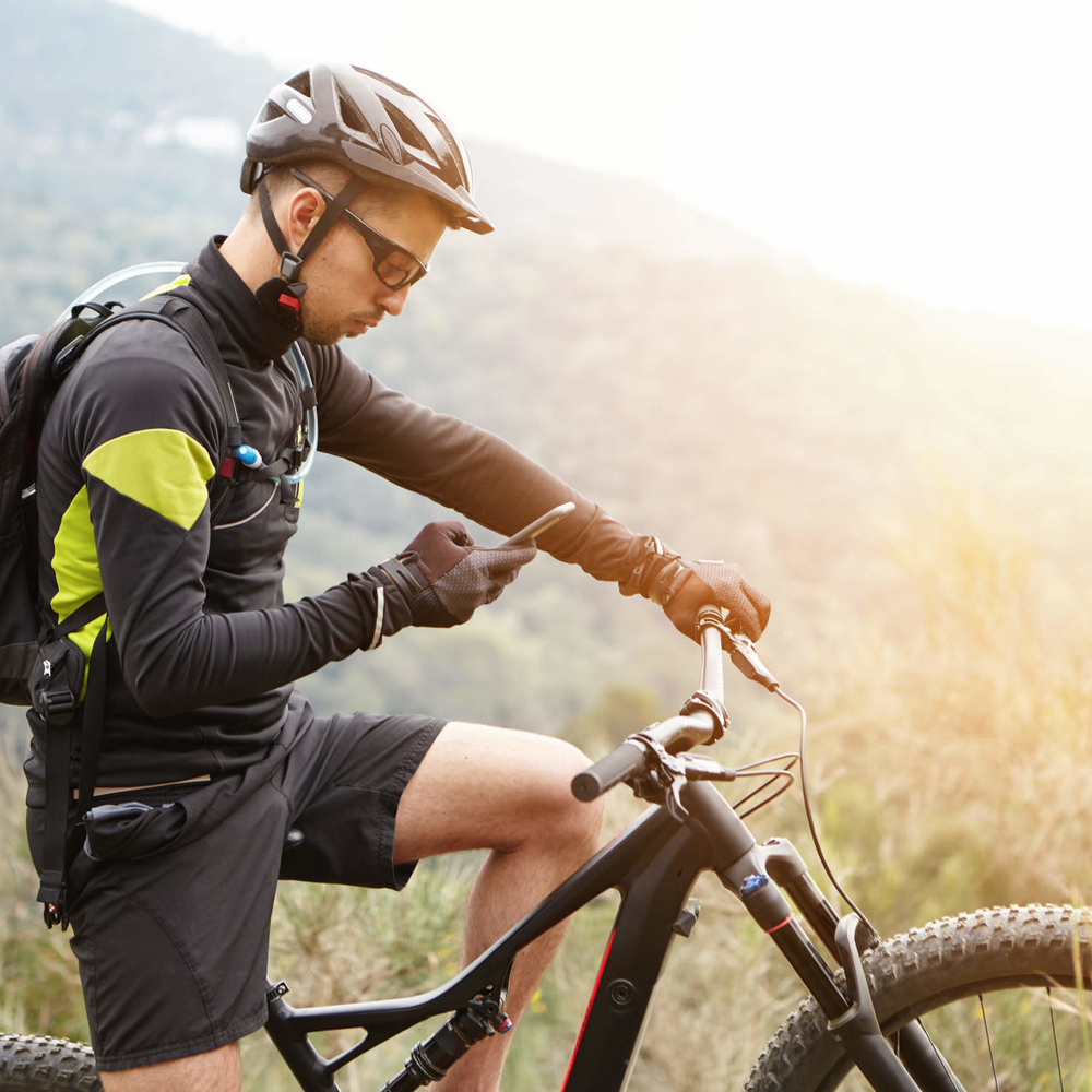 Bosch Fahrrad System mit App-Unterstützung Mann auf E-Bike nutzt ein Smartphone