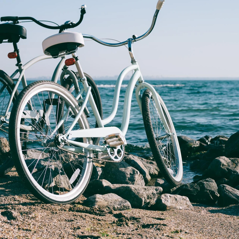Zwei Cruiser stehen auf einem Kiesstrand am Wasser