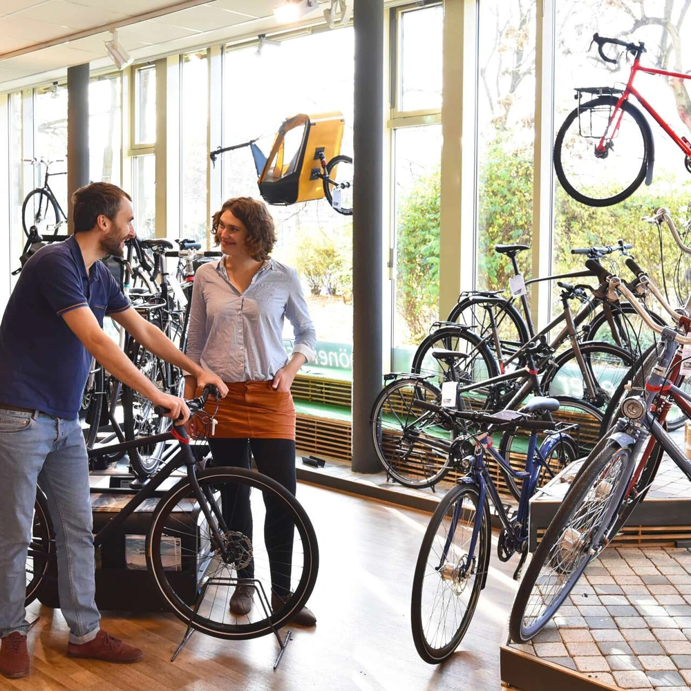 Zwei Personen unterhalten sich im Fahrradhandel.