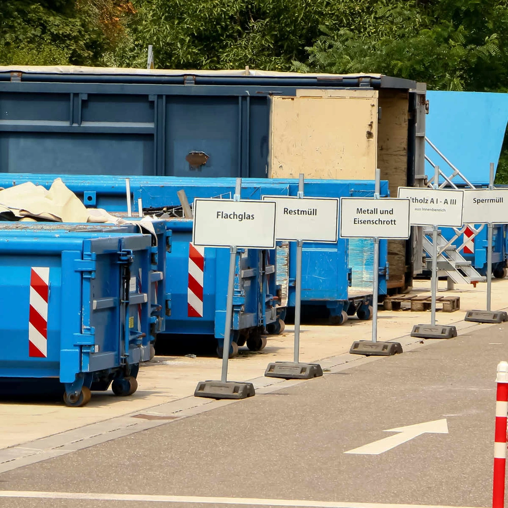 Wertstoffhof mit mehreren Containern und Stoppschild.
