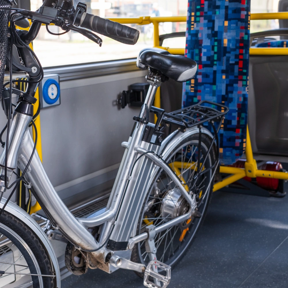 Ein Elektrofahrrad steht in einem öffentlichen Bus neben leeren Sitzplätzen.