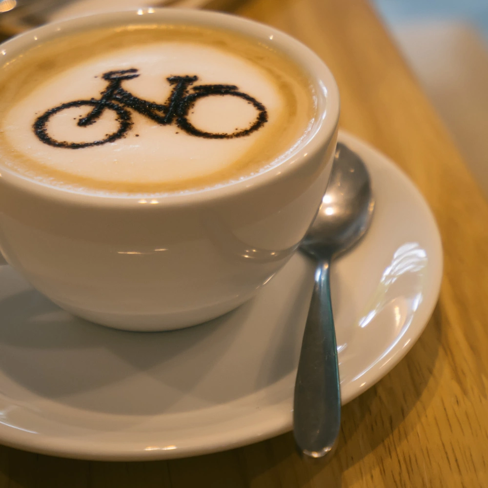 Eine Tasse Kaffee mit Milchschaum, auf dem ein Fahrrad als Latte Art zu sehen ist