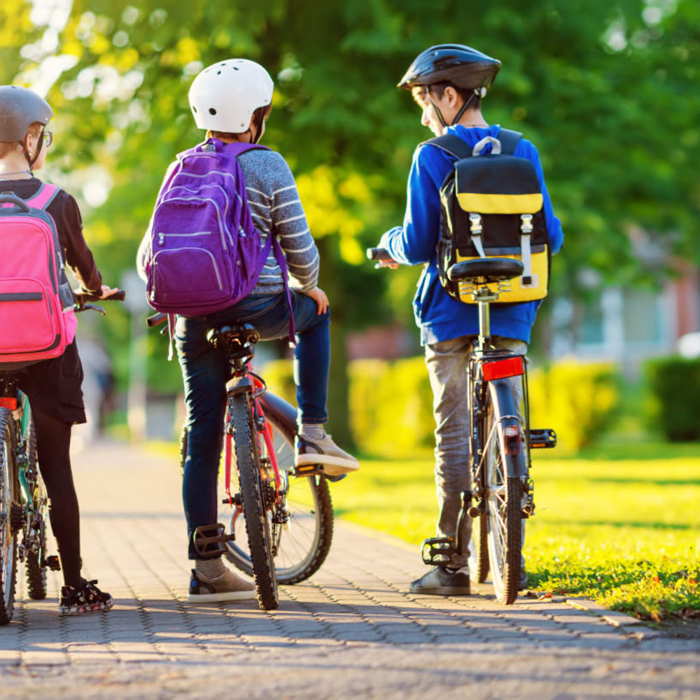 So ermitteln Sie die richtige Fahrradgröße mehrere Kinder mit Rucksack auf dem Fahrrad im Park