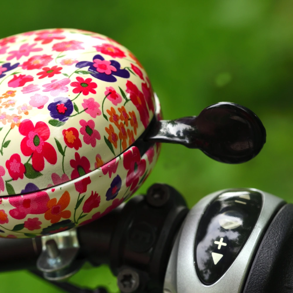 Nahaufnahme einer bunten Fahrradklingel an einem Fahrrad im Freien