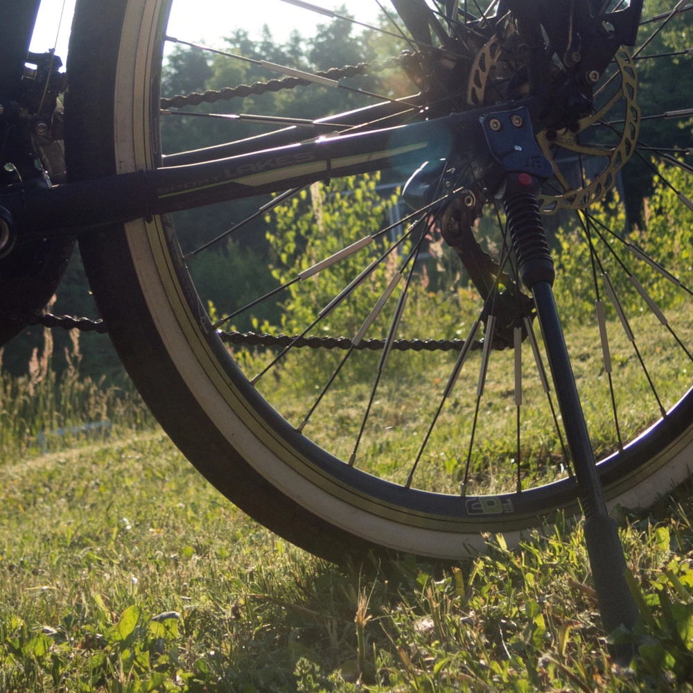 Nahaufnahme von einem Fahrradständer an einem abgestellten Fahrrad im Sonnenlicht