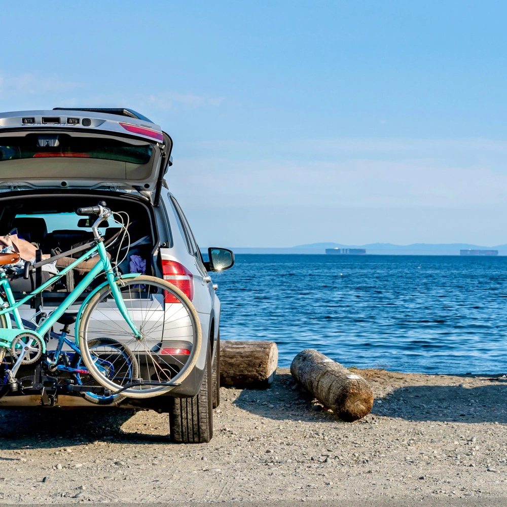 Auto mit einem Fahrradträger steht am Ufer eines Sees