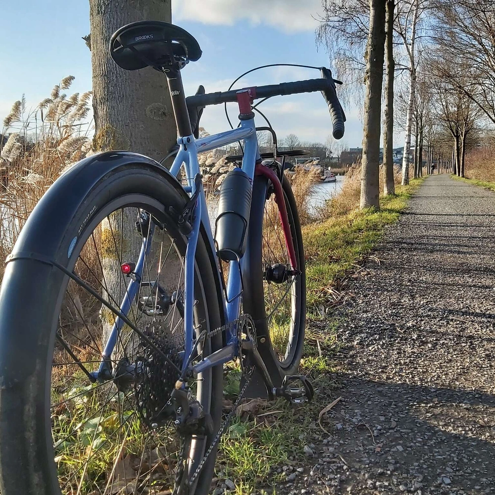 Ein Gravel Bike von hinten fotografiert auf einem Schotterweg bei sonnigem Winterwetter..