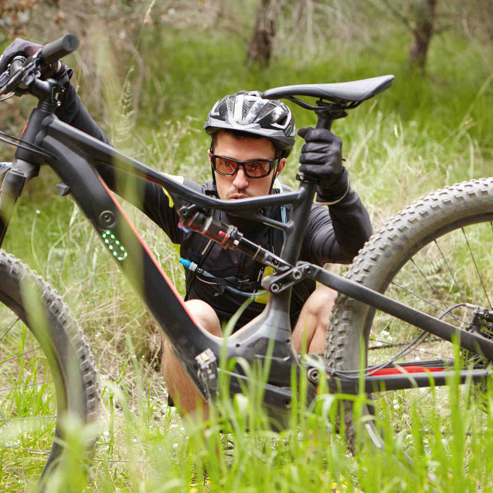 Warum der Sommer Ihrem E-Bike schadet Man betrachtet sein E-Bike und den Akku
