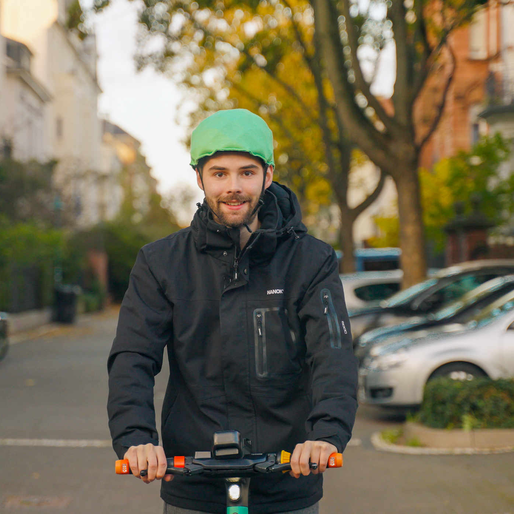 Inflabi: Der aufblasbare Fahrradhelm Mann auf E-Scooter fährt mit Inflabi Helm.