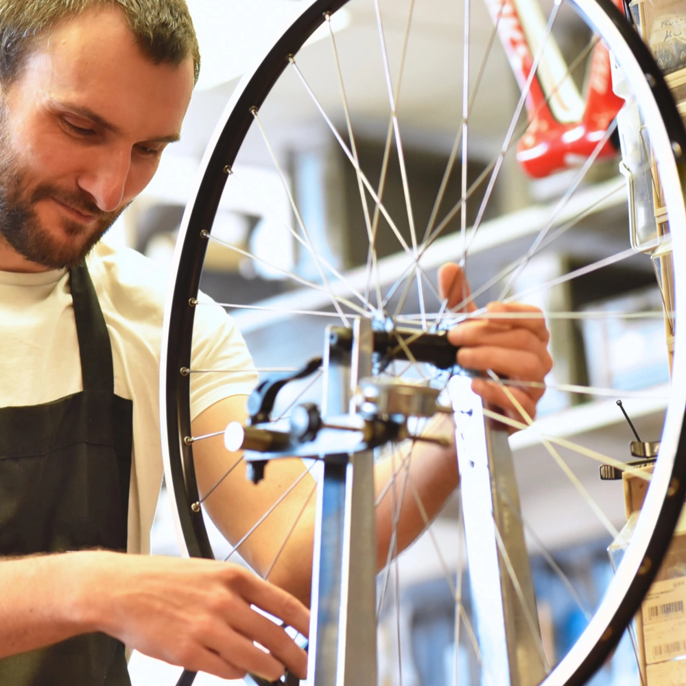 Mechaniker zentriert Laufrad eines Fahrrades in der Werkstatt 
