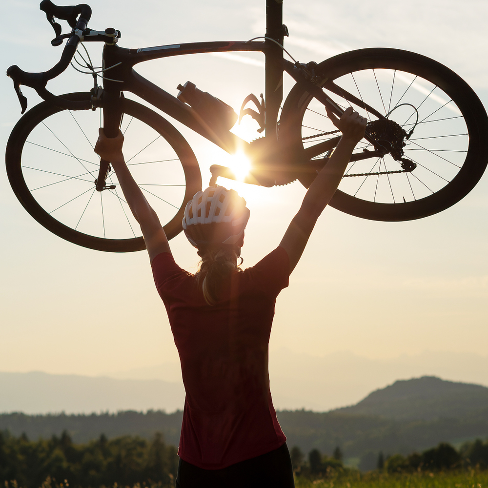 Rekordhalterin Lael Wilcox: Weltumrundung per Fahrrad Frau hält ihr Rennrad triumphal in die Luft