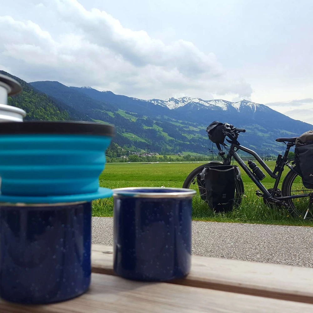 Fahrrad steht mit Reisegepäck auf einer Wiese.