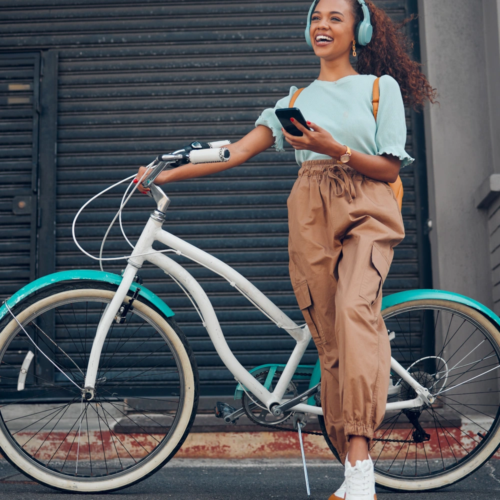 Frau steht vor ihrem Urban-Fahrrad in der Stadt.