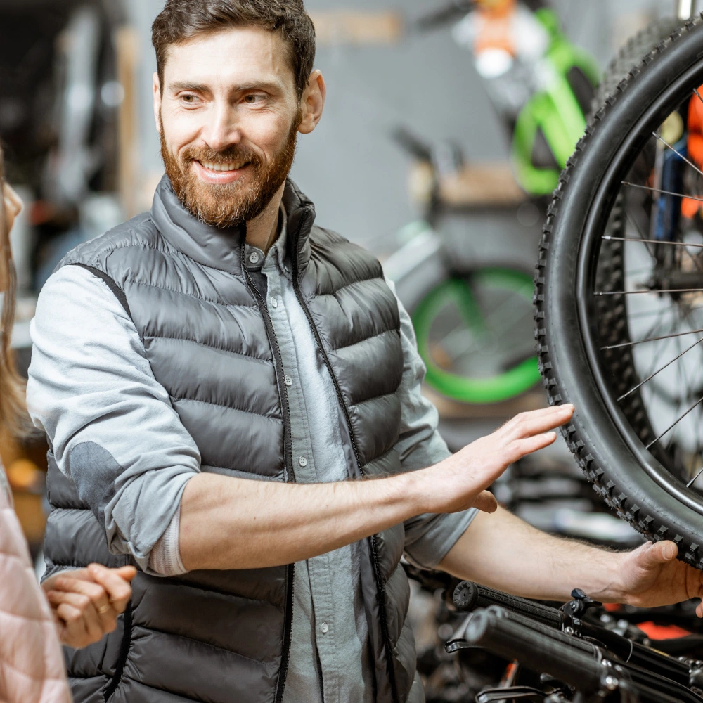 Fahrradverkäufer berät eine junge Frau in einem Fahrradladen