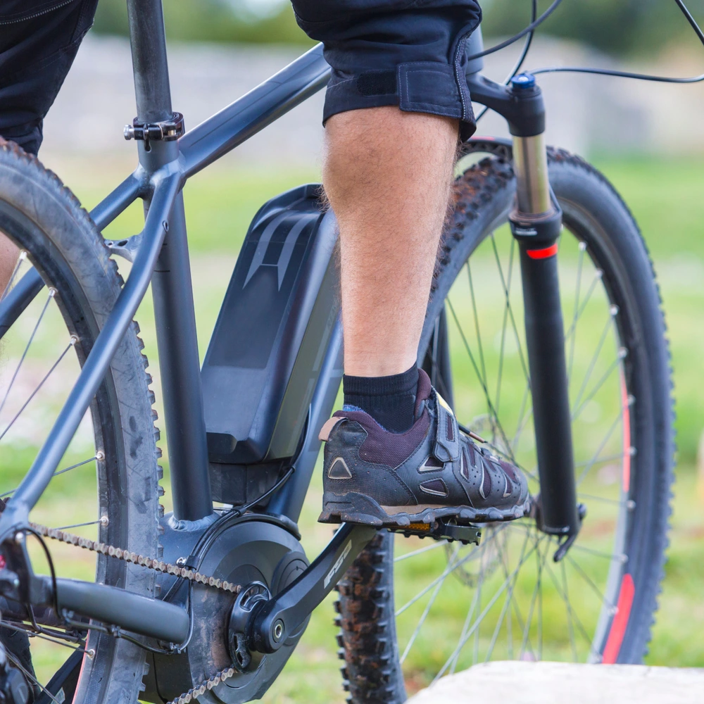Ein Radfahrer in Sportbekleidung, sitzt auf einem Mountainbike mit Yamaha Motor in der Natur