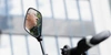 Marta Binder beim Tourenstopp in Hannover Fahrradrückspiegel mit reflektierenden Fenstern und einem weißen Helm im Hintergrund.
