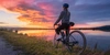 Das Canyon Endurace im Test Frau auf dem Fahrrad am Wasser während eines bunten Sonnenuntergangs.