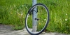 Ist Ihr Fahrrad verschwunden? Melden Sie den Diebstahl der Polizei. Ein Fahrradreifen ist an einer Laterne mit einer Fahrradkette angeschlossen.