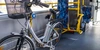 Fahrrad im Bus mitnehmen Ein Elektrofahrrad steht in einem öffentlichen Bus neben leeren Sitzplätzen.