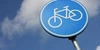 Mobilitätswende Blaue Fahrradsymbol-Schilder auf einem Pfosten vor einem Wolkenhimmel