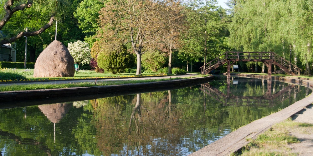 Ruhiger Spot im Spreewald mit Gewässer, Bäumen und einer Holzbrücke im Hintergrund