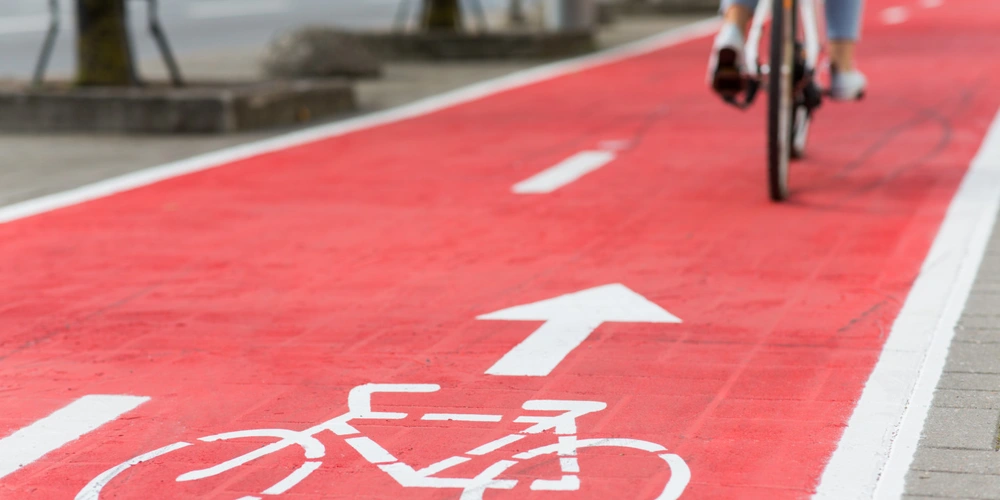 Ein Radfahrer auf einem Fahrradweg mit Fahrradsymbol und Pfeil