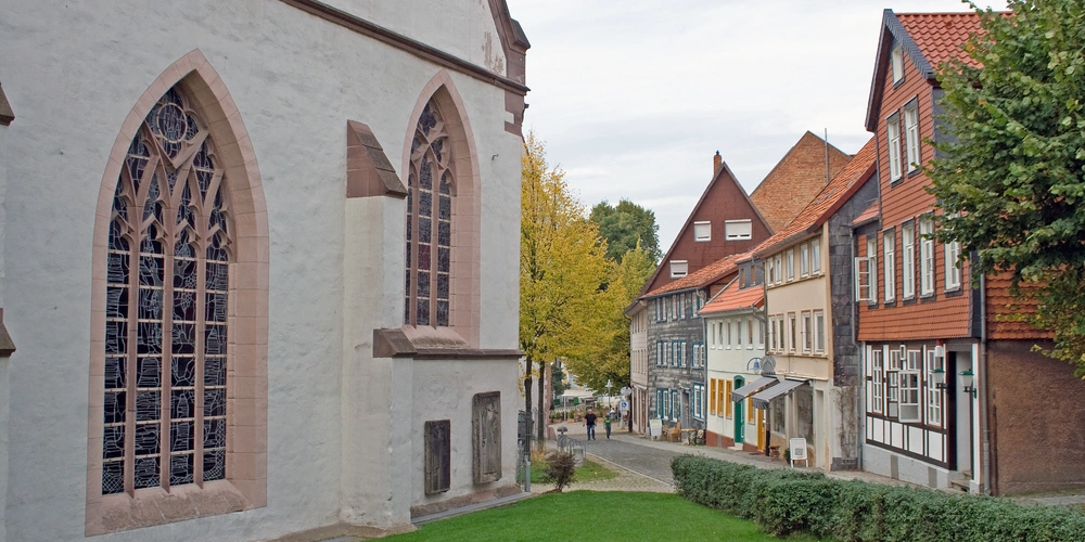 Blick auf eine charmante, historische Straße mit Fachwerkhäusern und einer Kirche.