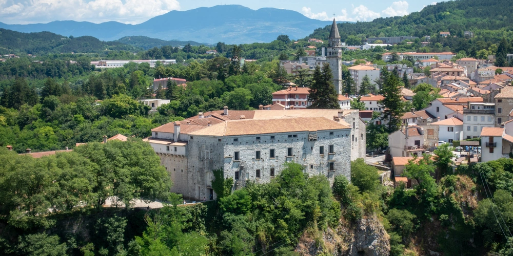 Die Ansicht der historischen Stadt Pazin mit einem alten Gebäude umgeben von grüner Landschaft.