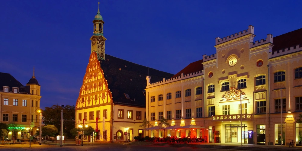 Historische Gebäude im Abendlicht, beleuchtet unter einem klaren, dunklen Himmel.